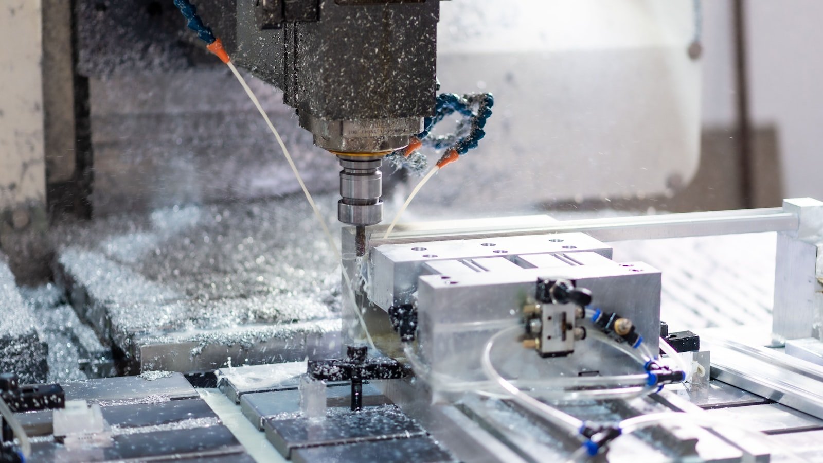 CNC mill cutting metal with coolant and chips flying