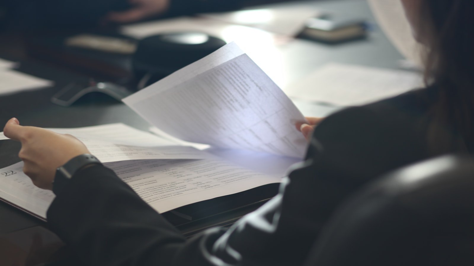 Attorney reviewing a printed document page by page at a desk